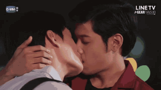 two men are kissing in front of a screen that says line tv