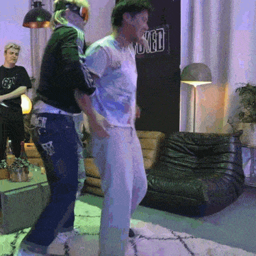 a man and woman are dancing in front of a sign that says ' skel '