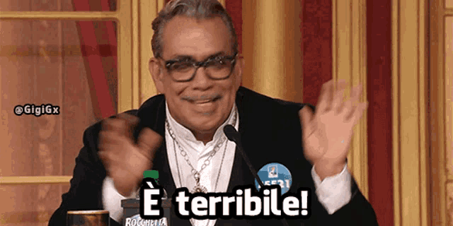 a man wearing glasses and a necklace says e terrible