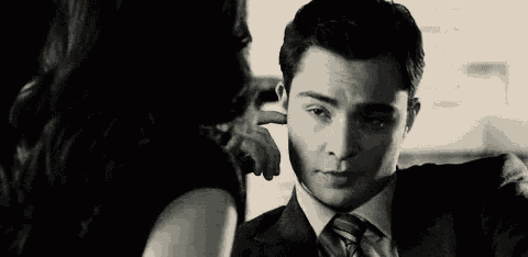 a man in a suit and tie is being touched by a woman in a black and white photo .