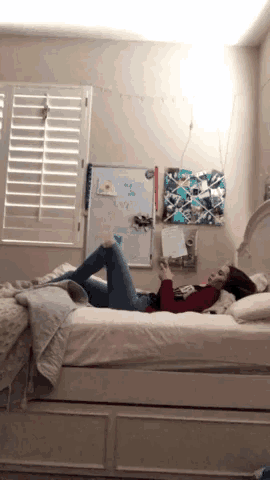 a girl is laying on her stomach on a bed in front of a white board that says ' i love you '