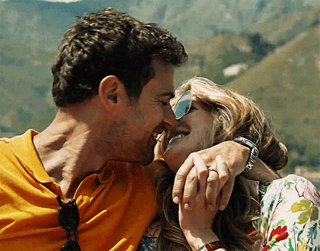 a man and a woman are kissing and the woman is wearing sunglasses