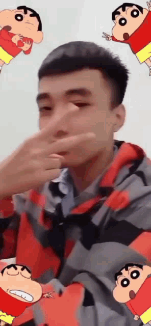 a man is covering his nose with his hand surrounded by crayon shin chan cartoon characters .
