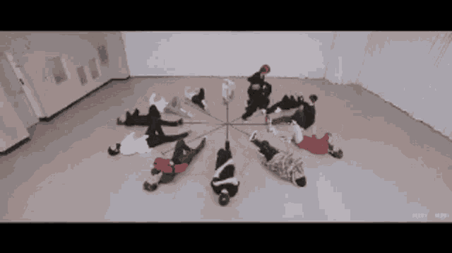 a group of people are laying in a circle in a room