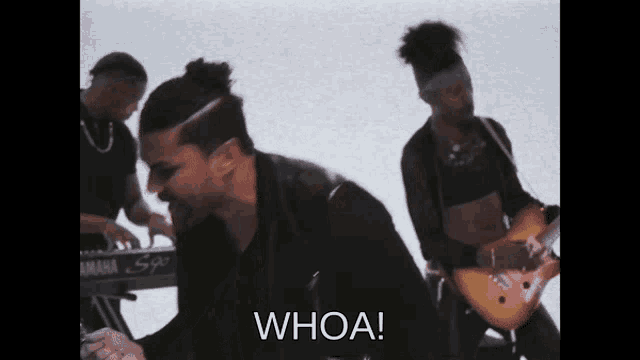 a man playing a guitar in front of a keyboard that says whoa on it