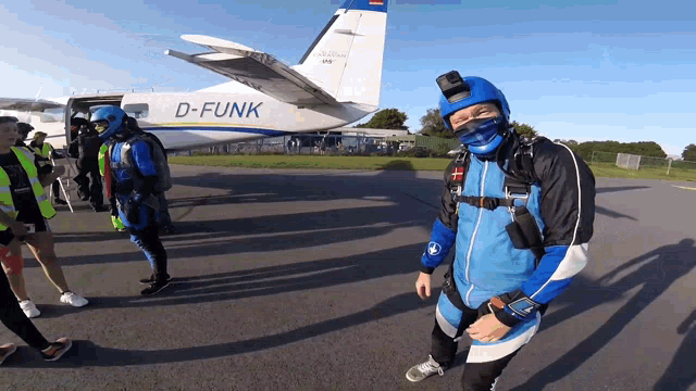 a man stands in front of a plane that says d-funk on the tail