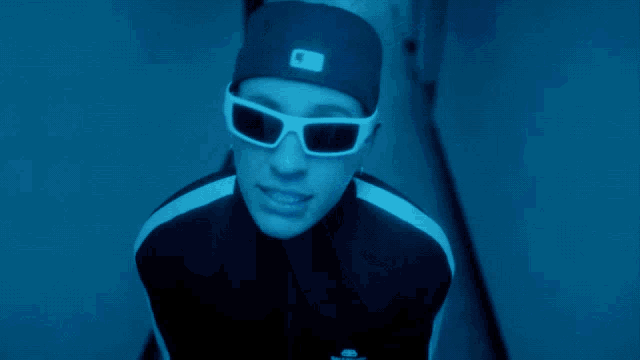 a close up of a person wearing white sunglasses in a blue light