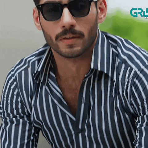 a man wearing sunglasses and a striped shirt has a green logo in the background