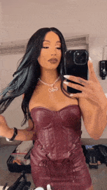 a woman is taking a picture of herself in a mirror with her phone