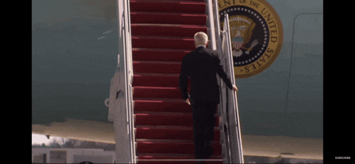 a man climbs the stairs of an air force one