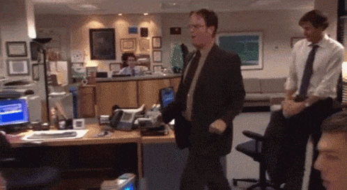 a man in a suit and tie stands in an office