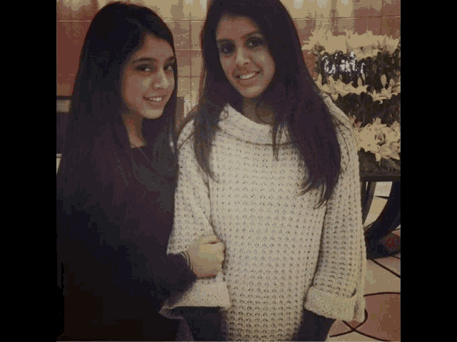 two girls are standing next to each other and smiling for the camera