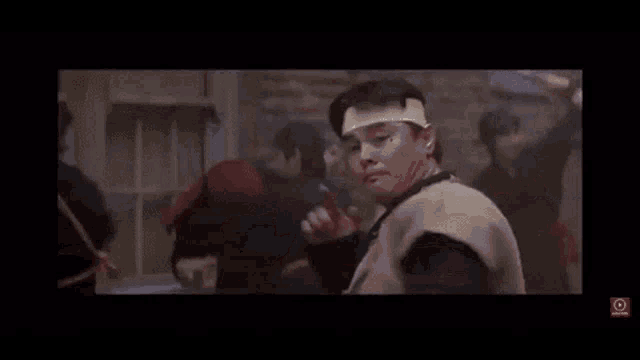 a young man is holding a sword in his hand in a movie .