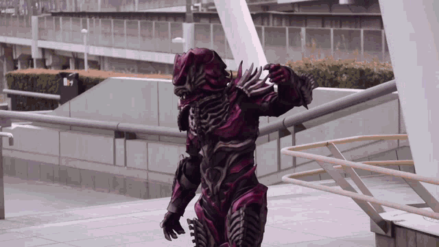 a man in a purple and black costume is walking down a sidewalk