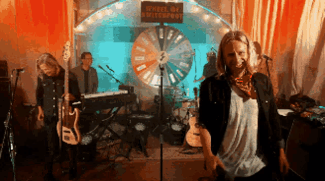 a group of musicians are standing in front of a sign that says wheel of switchfoot
