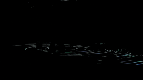 a person stands in a dark room surrounded by a circle of lights