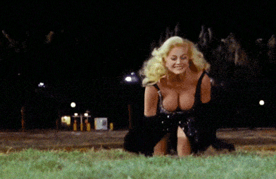 a woman with blonde hair is kneeling down in the grass at night