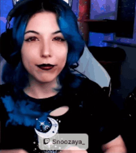 a woman with blue hair is wearing headphones and a shirt that says snoozaya