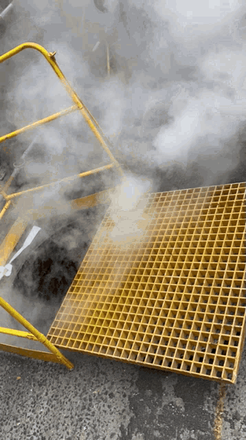smoke is coming out of a hole in a yellow grate