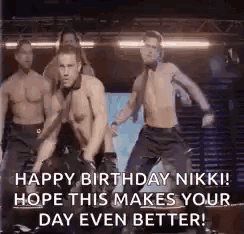 a group of shirtless men are dancing on a stage in a dark room .