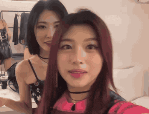 a woman with red hair is standing next to another woman with black hair
