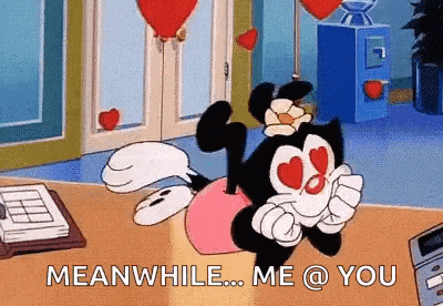 a cartoon character with hearts on his eyes is sitting on a table with balloons in the background .
