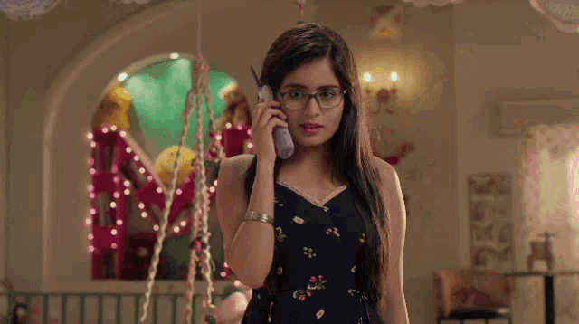 a woman wearing glasses talks on a cell phone