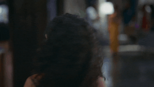 a woman with curly hair looks at the camera