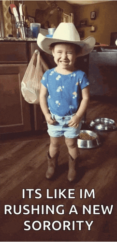 a little girl wearing a cowboy hat and shorts is smiling