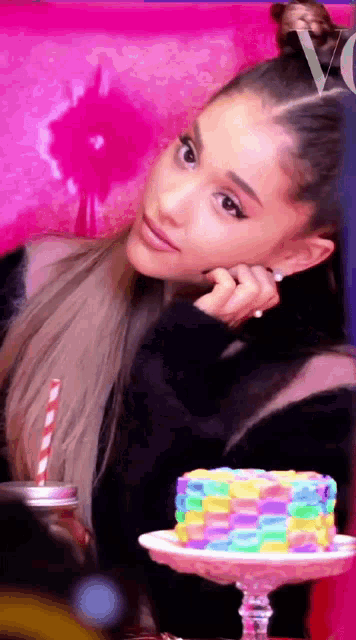 a woman sitting in front of a cake with a straw