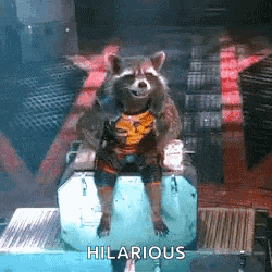 rocket raccoon from guardians of the galaxy is sitting on top of a box .