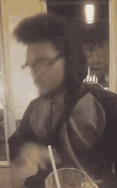 a blurry picture of a man drinking from a glass
