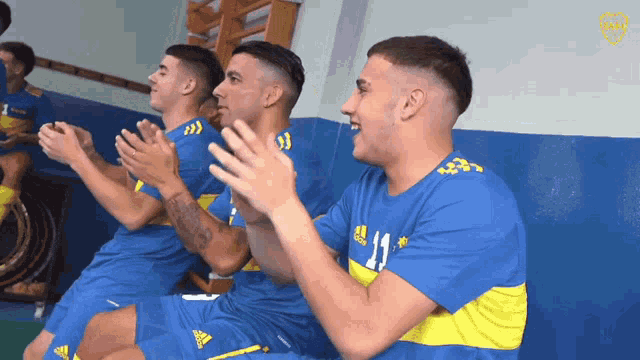 a group of soccer players wearing blue and yellow jerseys with the number 11
