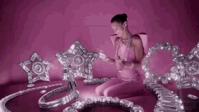 a woman in a pink outfit is surrounded by a bunch of jewelry .