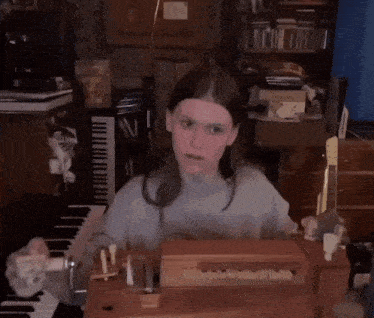 a woman playing a small organ in front of a piano keyboard