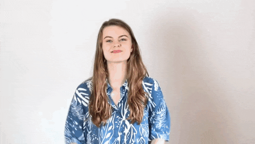 a woman in a blue shirt with leaves on it is smiling