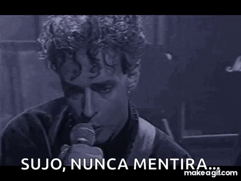 a man singing into a microphone with the words sujo nunca mentira written below him .
