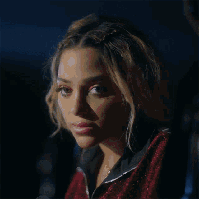 a close up of a woman 's face in a red jacket