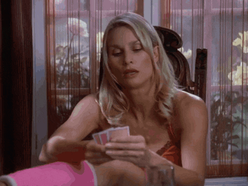 a woman is playing a game of cards with a pink socks on her leg