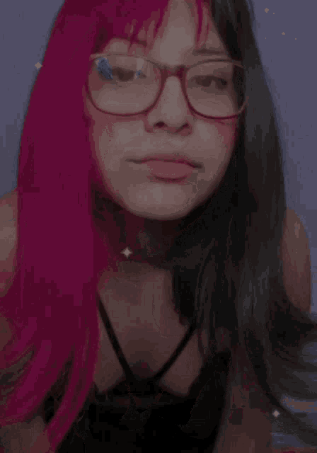 a girl with pink hair and glasses is wearing a black top and a choker .