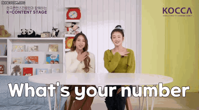 two women are sitting at a table with the words what 's your number written on the table