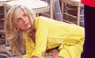 a woman in a yellow dress is crawling on the floor and says bitch .