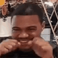 a man is smiling and making a funny face with his hands in his fist .