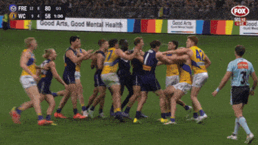 a group of soccer players are fighting on a field with a fox logo in the background
