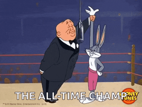 bugs bunny is standing next to a man in a tuxedo in a boxing ring holding a trophy .
