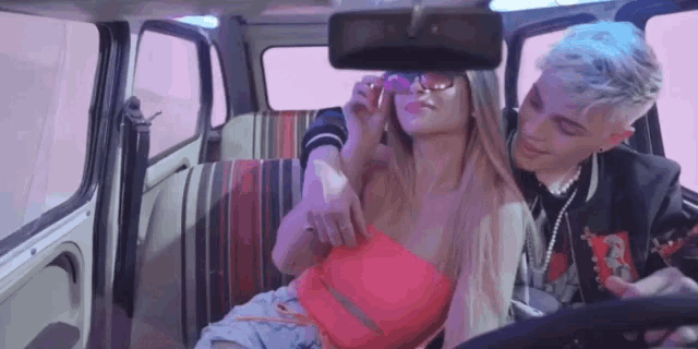 a man is driving a car with a woman sitting in the back seat .