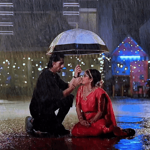 a man holds an umbrella over a woman kneeling down in the rain