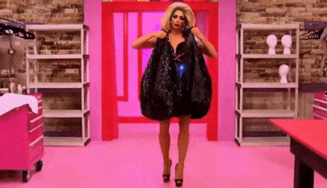 a drag queen is holding a very large bag in a room .