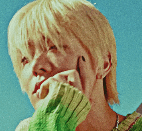 a close up of a person 's face against a blue sky