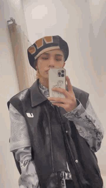 a man is taking a picture of himself in a mirror with his phone .